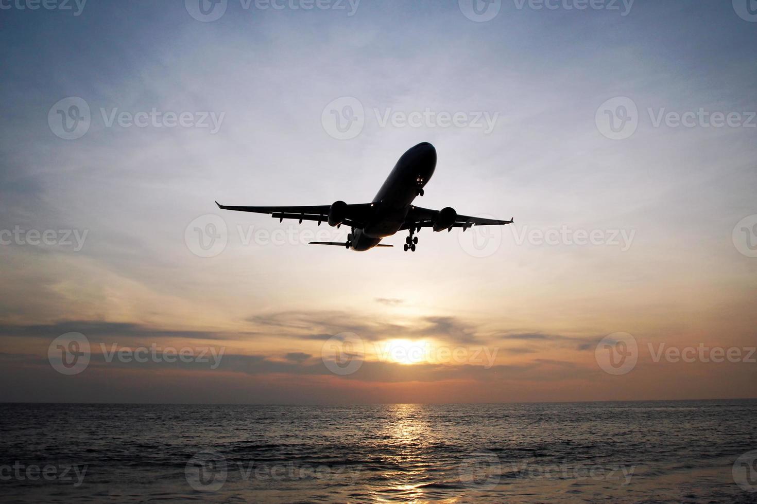 The beautiful view on a sea with plane in a sky during a colorful sunset. Phuket, Thailand. photo