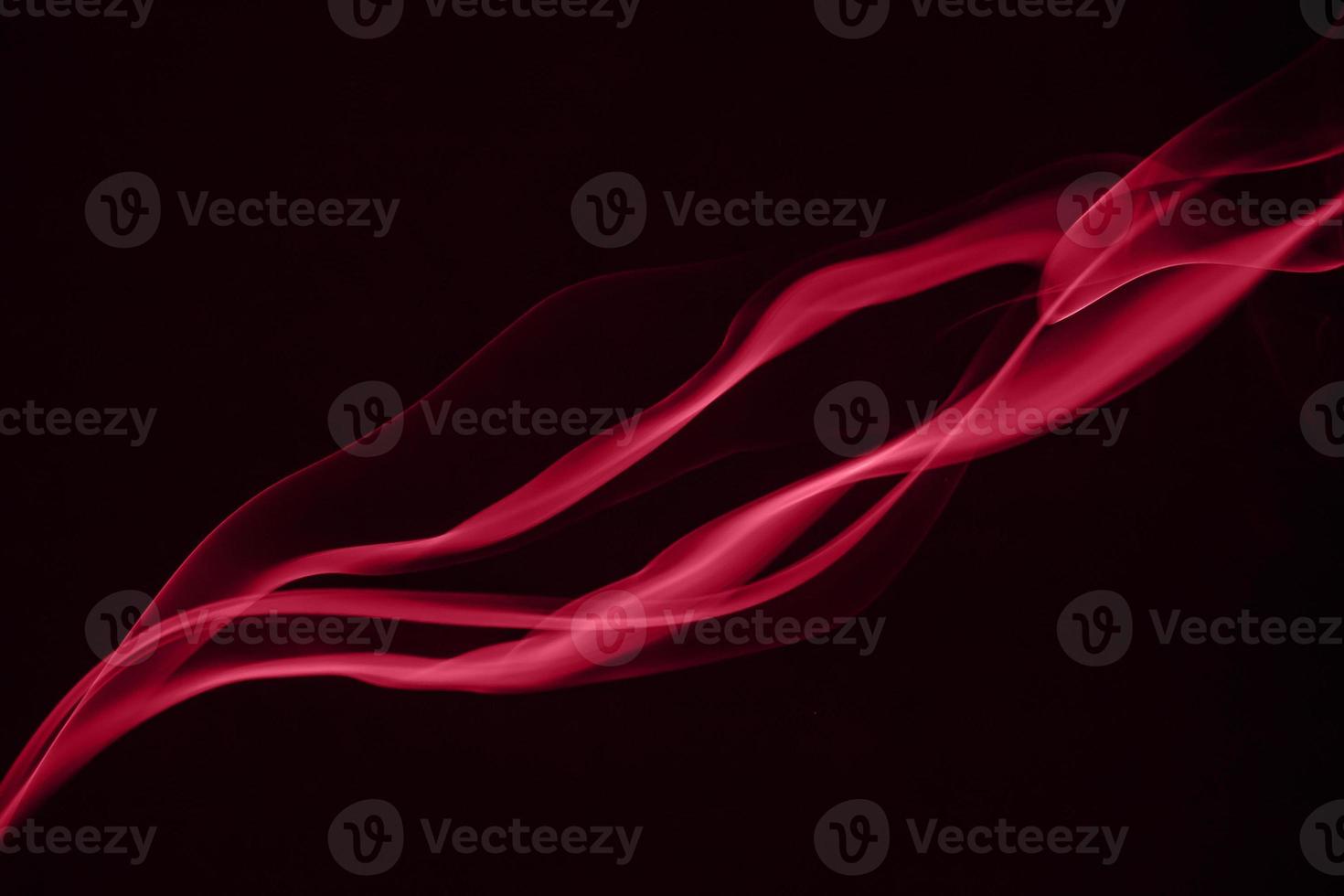 Red puffs of smoke on black background. Color of the year 2023 - Viva Magenta photo