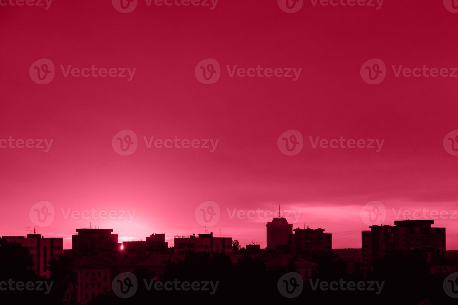 silueta de la ciudad al atardecer. paisaje urbano al amanecer. color del año 2023 - magenta viva foto