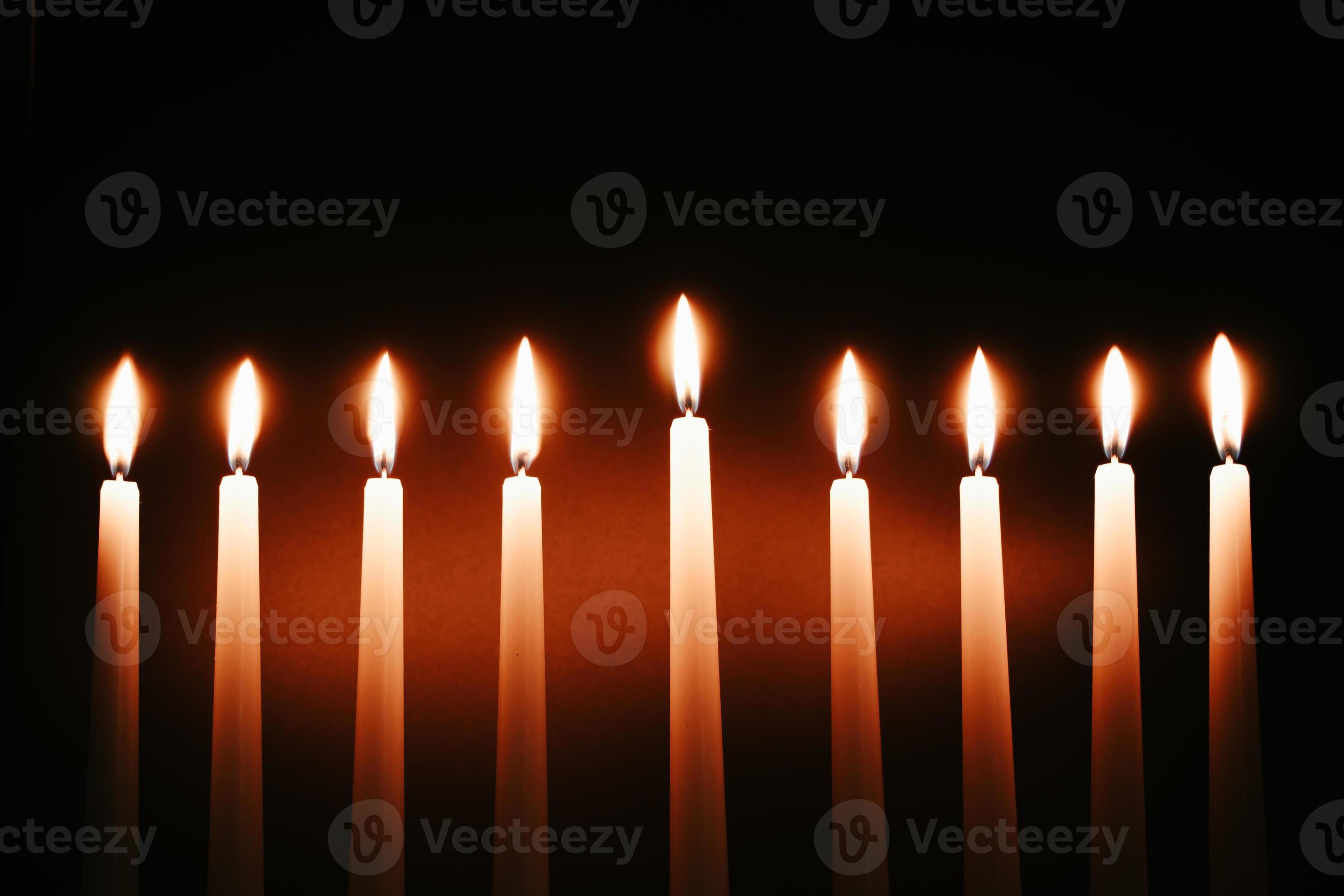 Hanukkah candles. Traditional candelabrum with burning candles on black