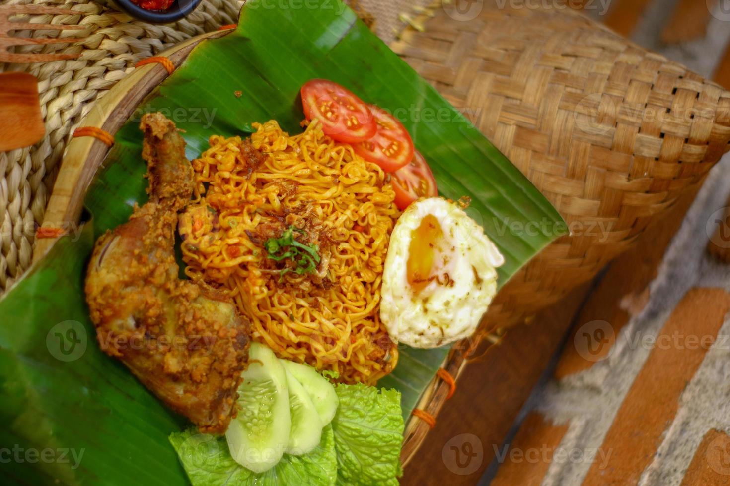 spicy noodle food with additional omelet and fried chicken photo