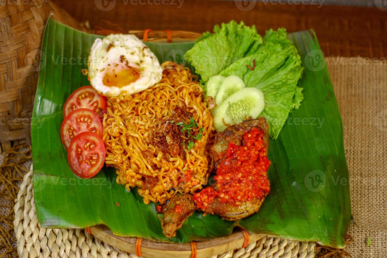 spicy noodle food with additional omelet and fried chicken photo