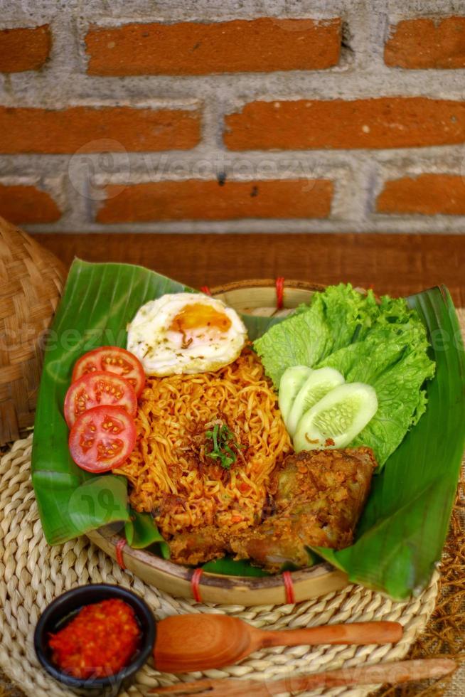 spicy noodle food with additional omelet and fried chicken photo