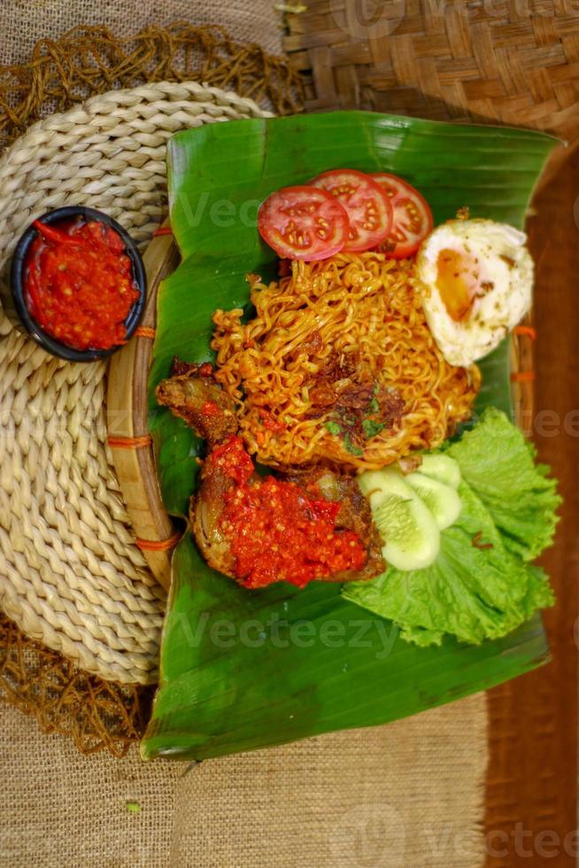 spicy noodle food with additional omelet and fried chicken photo