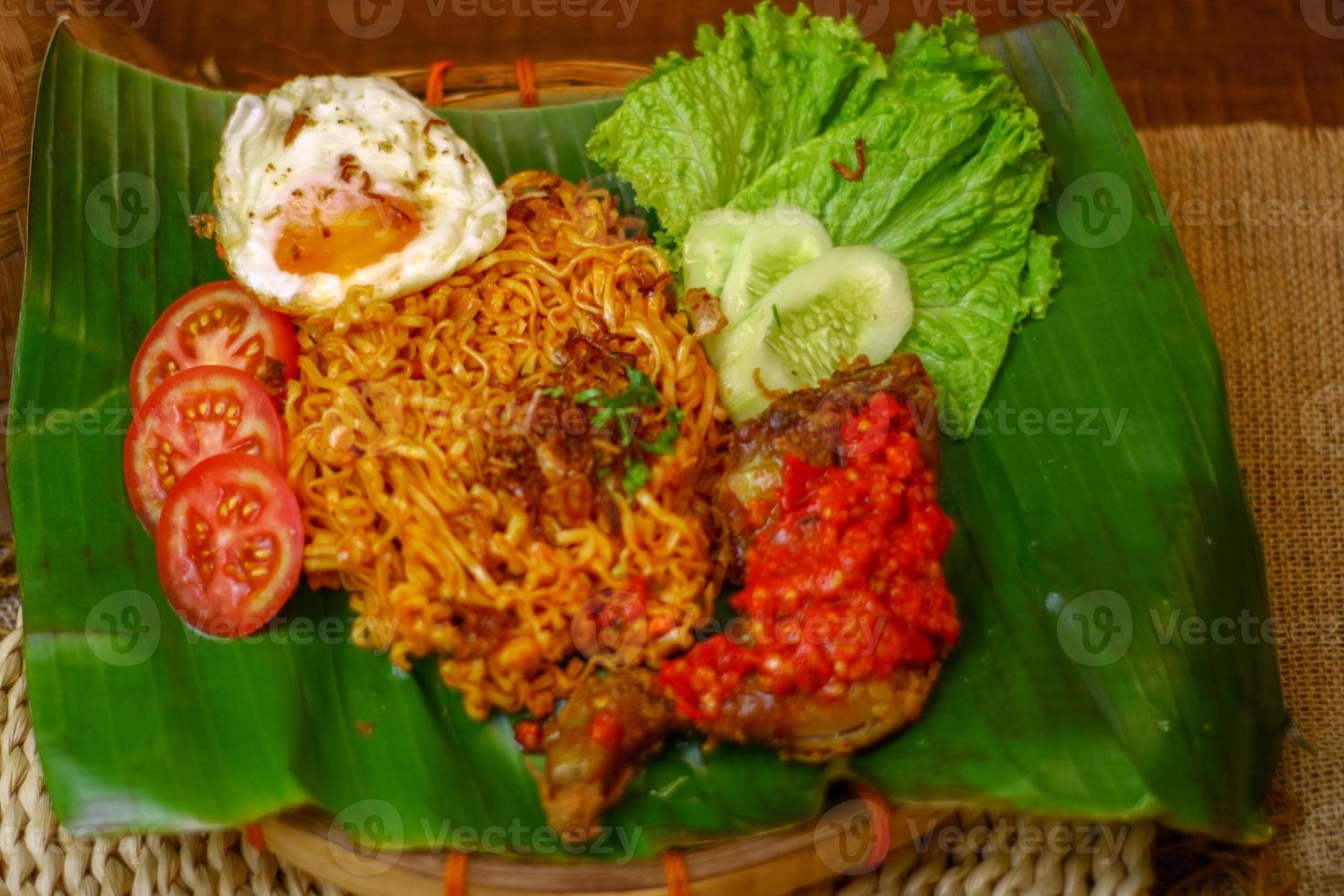 spicy noodle food with additional omelet and fried chicken photo