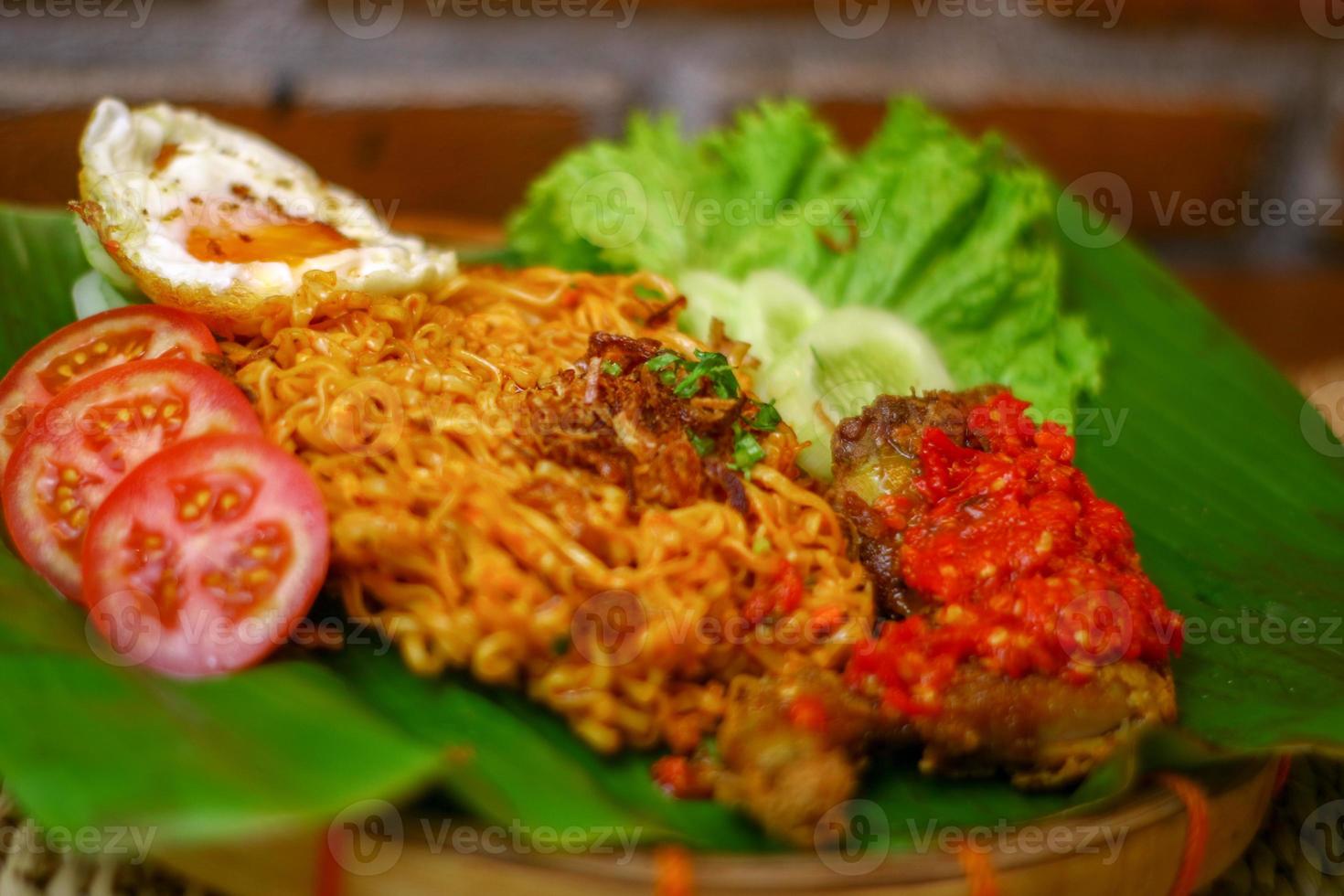 spicy noodle food with additional omelet and fried chicken photo