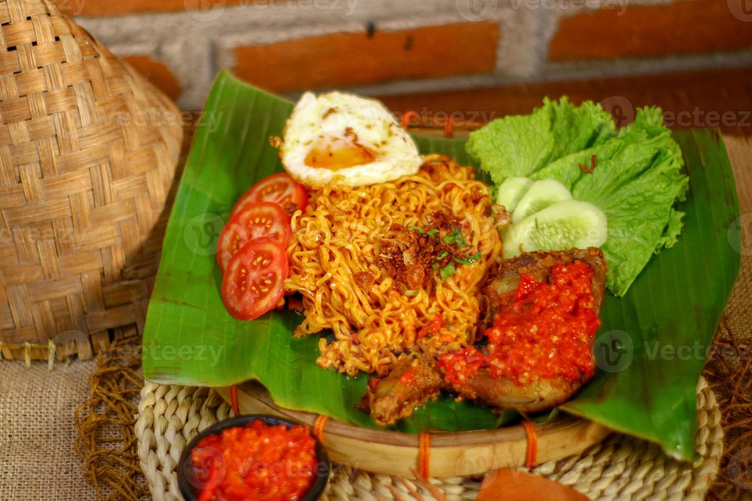 spicy noodle food with additional omelet and fried chicken photo