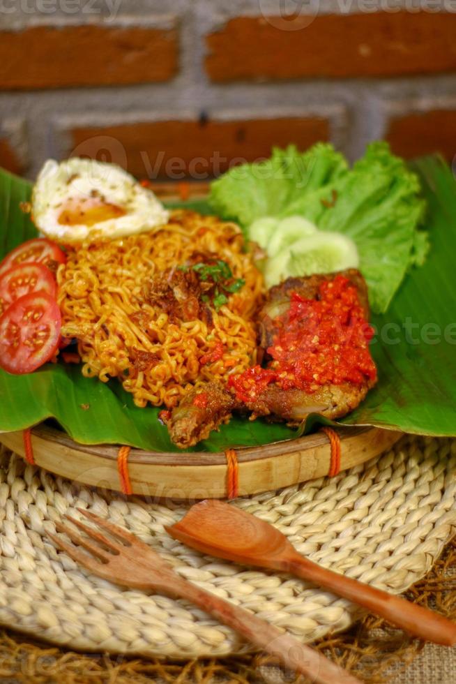 spicy noodle food with additional omelet and fried chicken photo