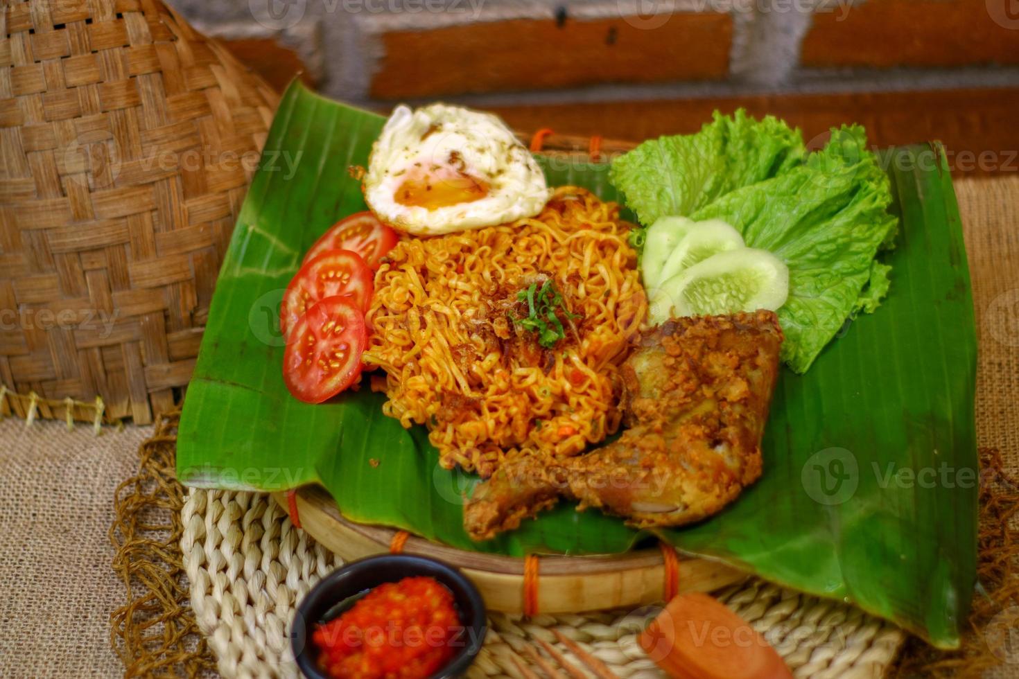 spicy noodle food with additional omelet and fried chicken photo