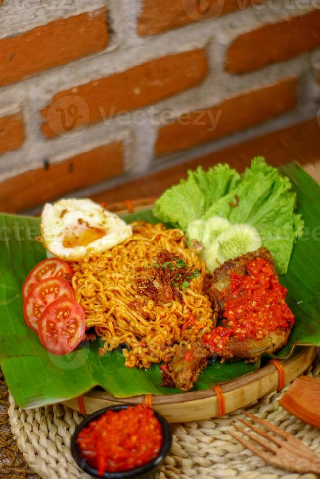 spicy noodle food with additional omelet and fried chicken photo