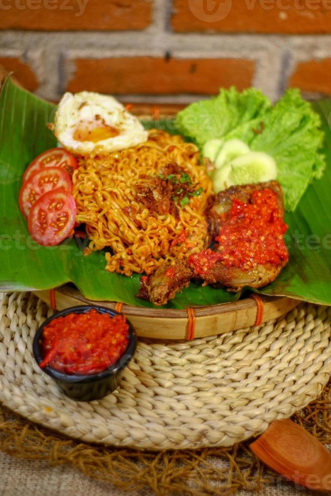 spicy noodle food with additional omelet and fried chicken photo