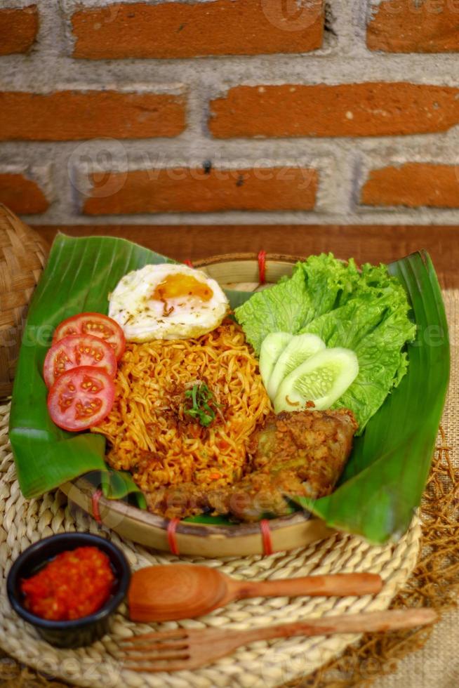 spicy noodle food with additional omelet and fried chicken photo