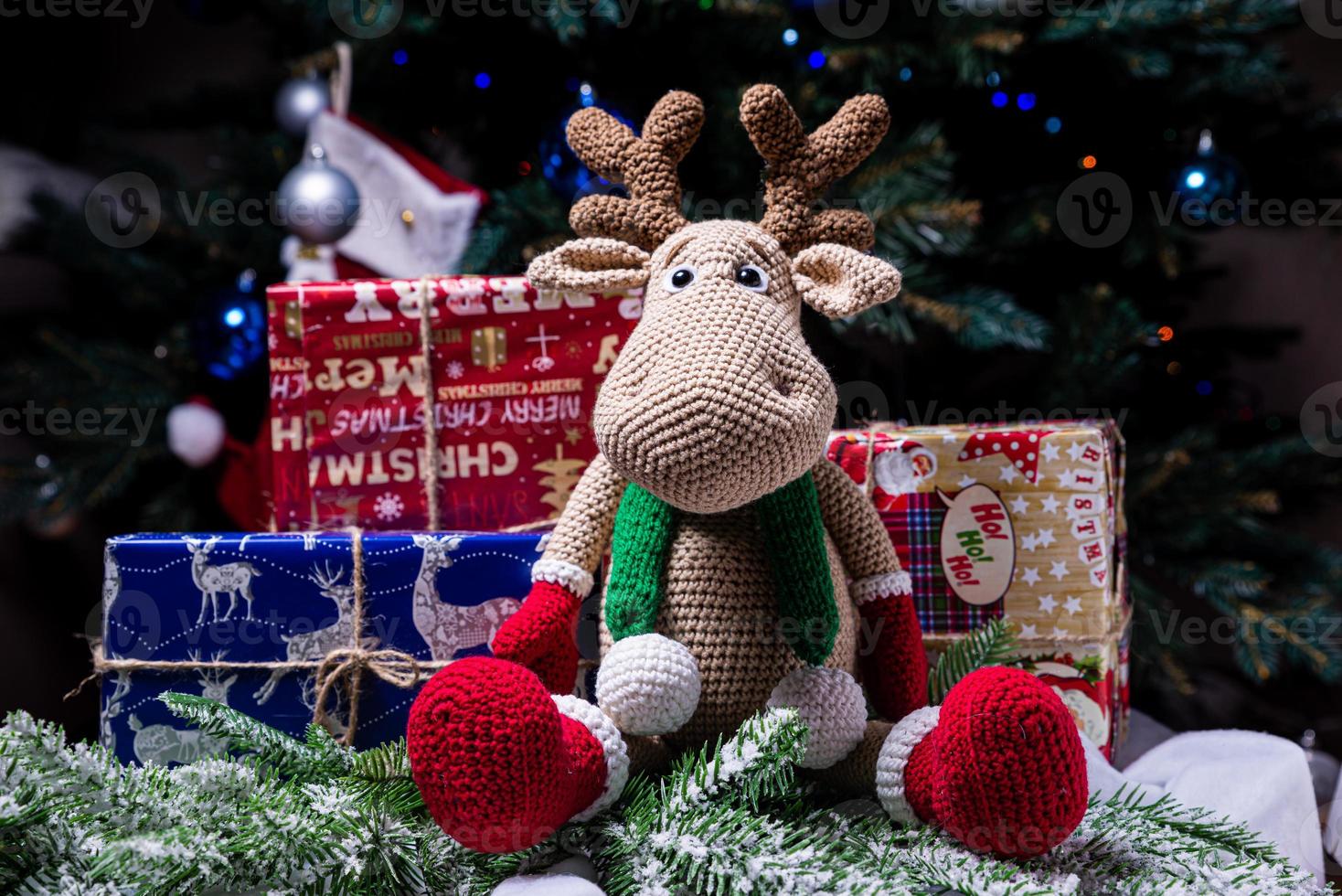 knitted elk. cute moose. toy against the background of a New Year's garland, knitted hare and elk on a Christmas tree photo