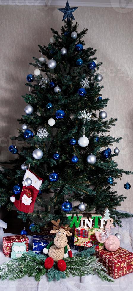Christmas, New Year interior with red brick wall background, decorated fir tree with garlands and balls, dark drawer photo