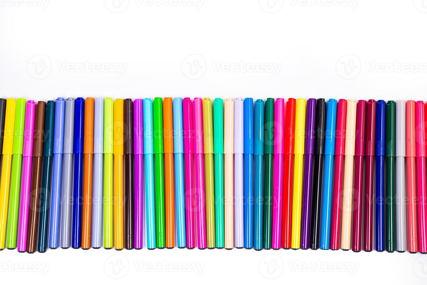 A set of multi-colored felt-tip pens in a row, rainbow on a light white banner background. Drawing markers, pencils, ink, artist tools, creativity, leisure, hobby. Colorful school supplies. photo