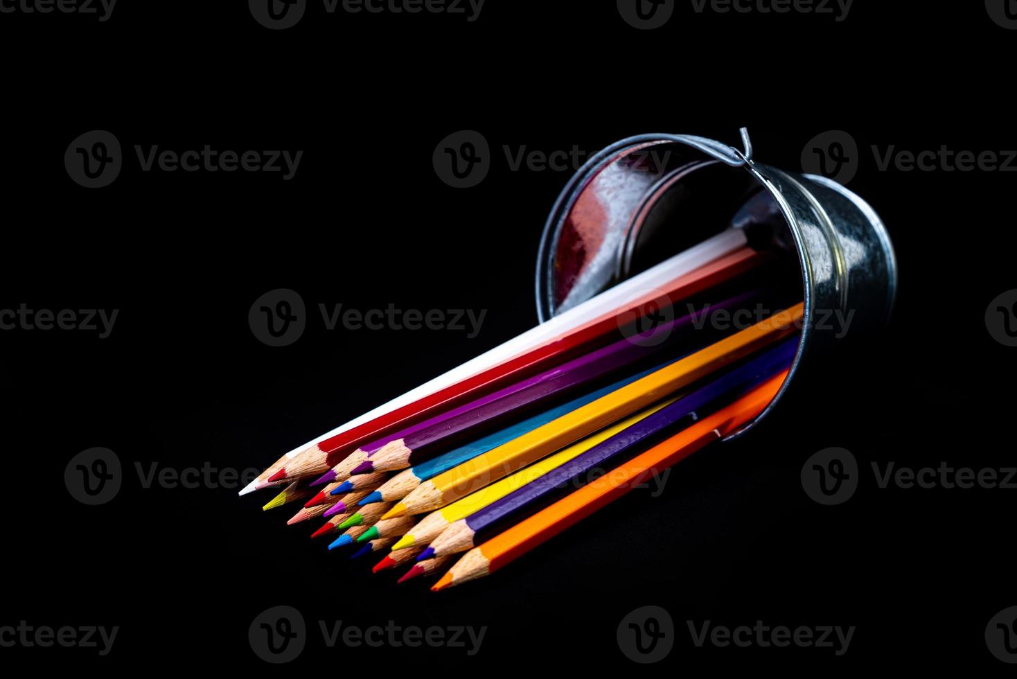 multi-colored pencils in a wine glass and a bucket. Selective blurred a group of coloring pencils in a wine glass on the isolated white or black background , Modern art. Modern photo