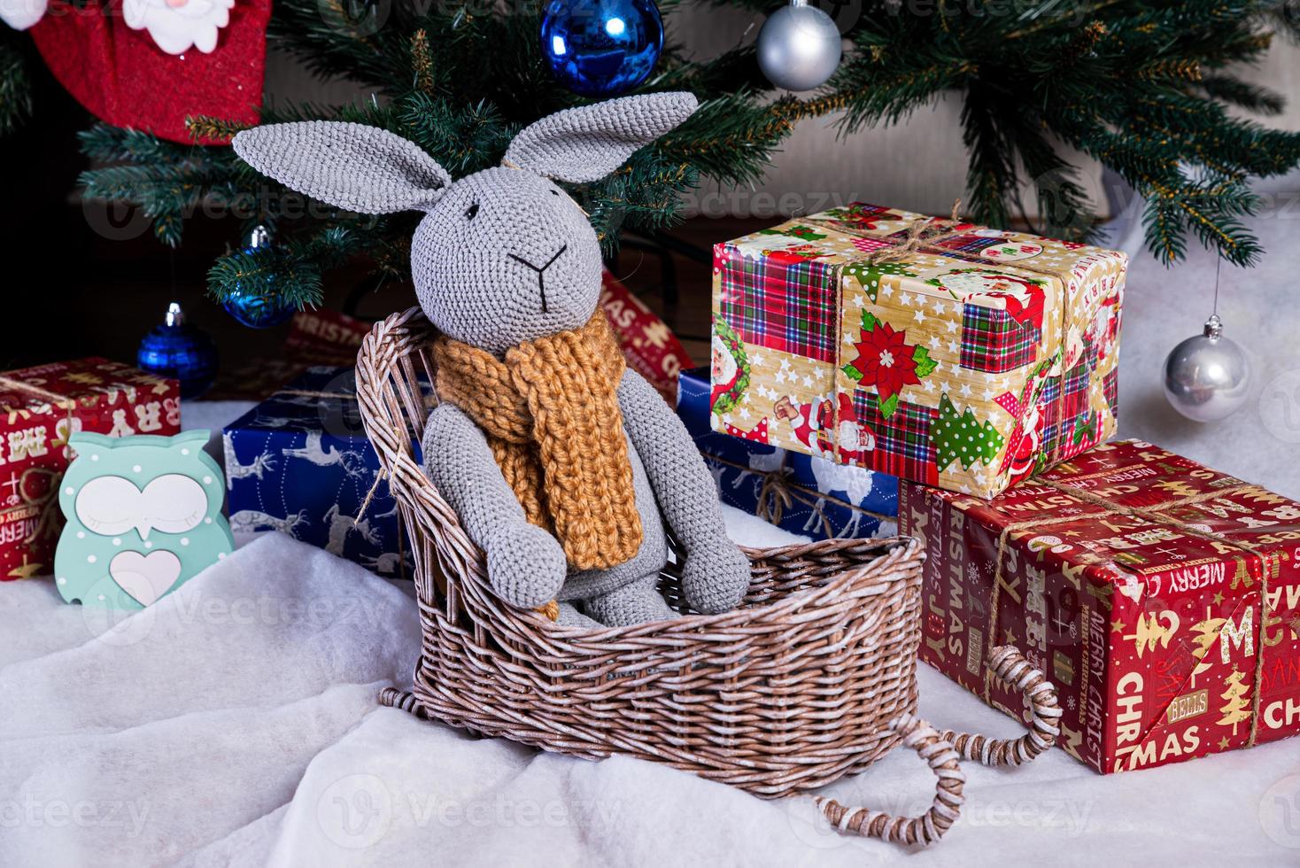 knitted elk. cute moose. toy against the background of a New Year's garland, knitted hare and elk on a Christmas tree photo