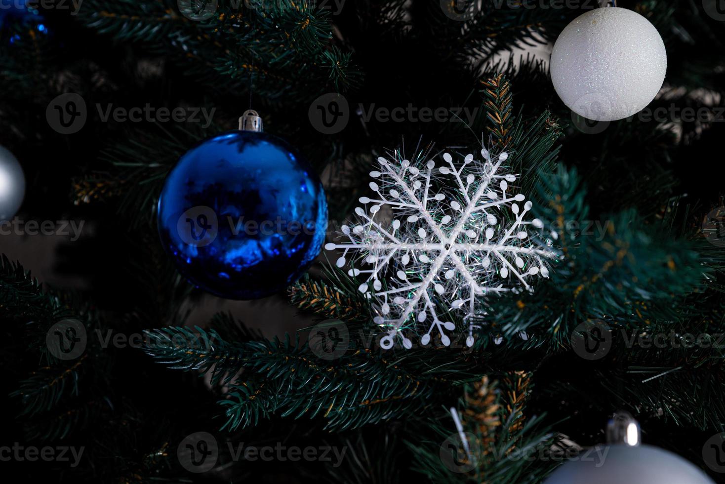 árbol de navidad con bolas de colores y cajas de regalo sobre una pared de ladrillo blanco con bolas azules y blancas foto