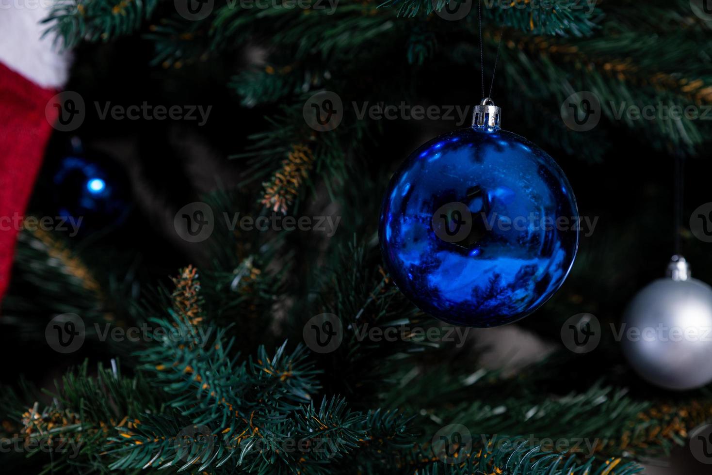 christmas tree with colorful balls and gift boxes over white brick wall with blue and white balls photo