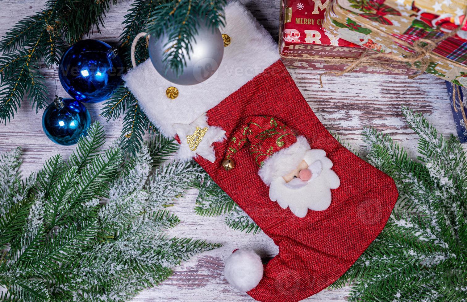 Flat lay composition with serpentine streamers and Christmas decor on wooden background. Space for text Balls, branches, hat, photo