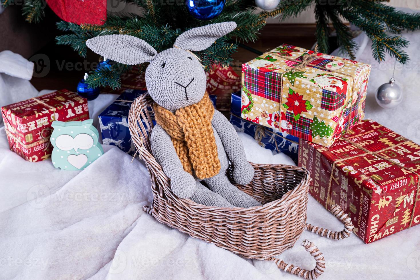 knitted elk. cute moose. toy against the background of a New Year's garland, knitted hare and elk on a Christmas tree photo