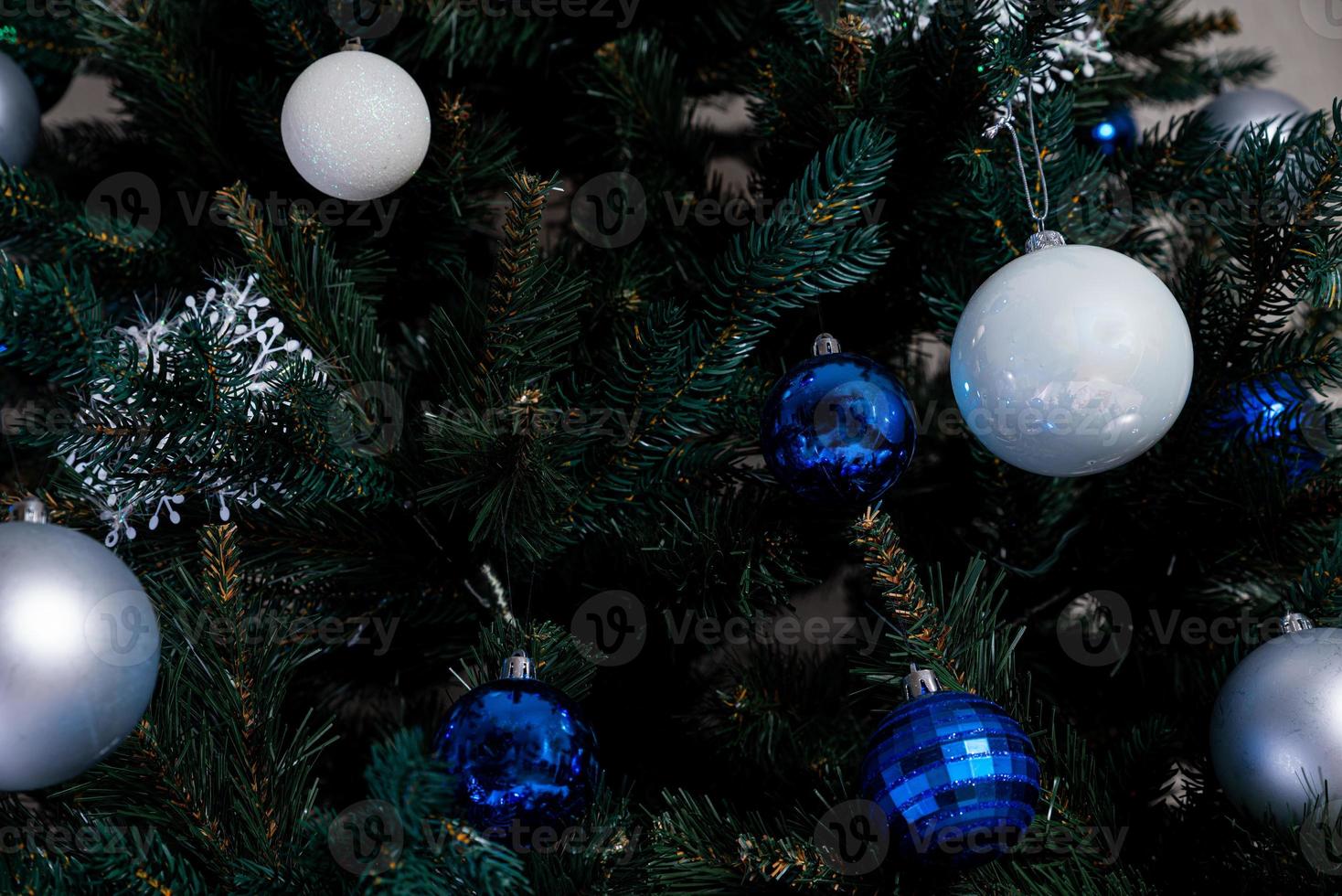 christmas tree with colorful balls and gift boxes over white brick wall with blue and white balls photo