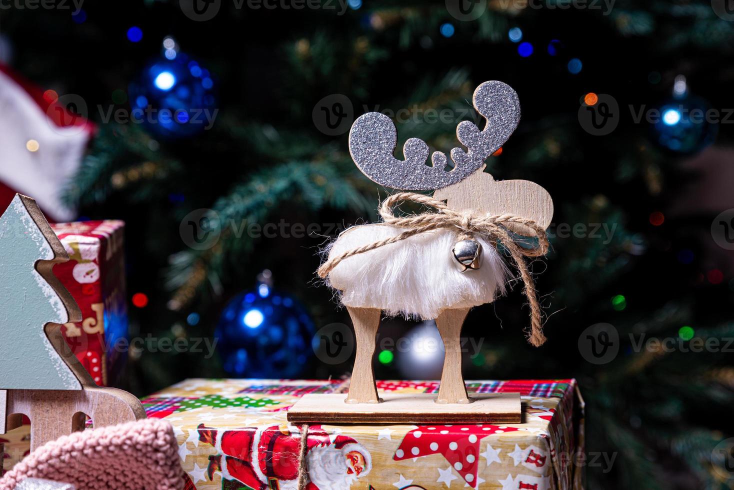 knitted elk. cute moose. toy against the background of a New Year's garland, knitted hare and elk on a Christmas tree photo