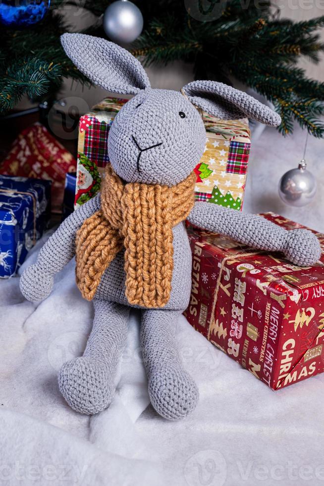 knitted elk. cute moose. toy against the background of a New Year's garland, knitted hare and elk on a Christmas tree photo