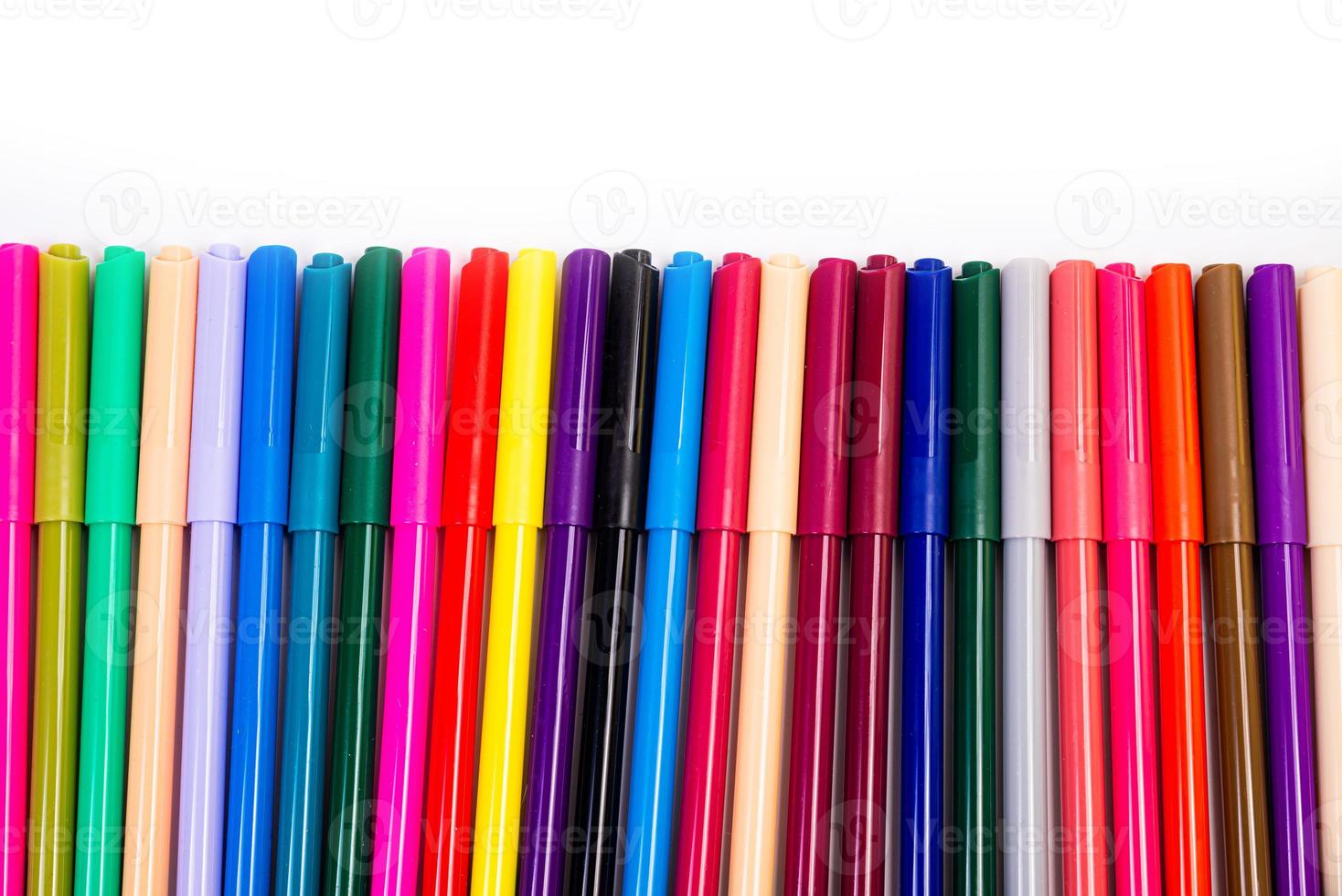 A set of multi-colored felt-tip pens in a row, rainbow on a light white banner background. Drawing markers, pencils, ink, artist tools, creativity, leisure, hobby. Colorful school supplies. photo