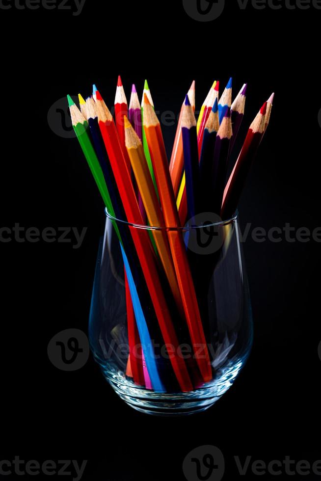 multi-colored pencils in a wine glass and a bucket. Selective blurred a group of coloring pencils in a wine glass on the isolated white or black background , Modern art. Modern photo