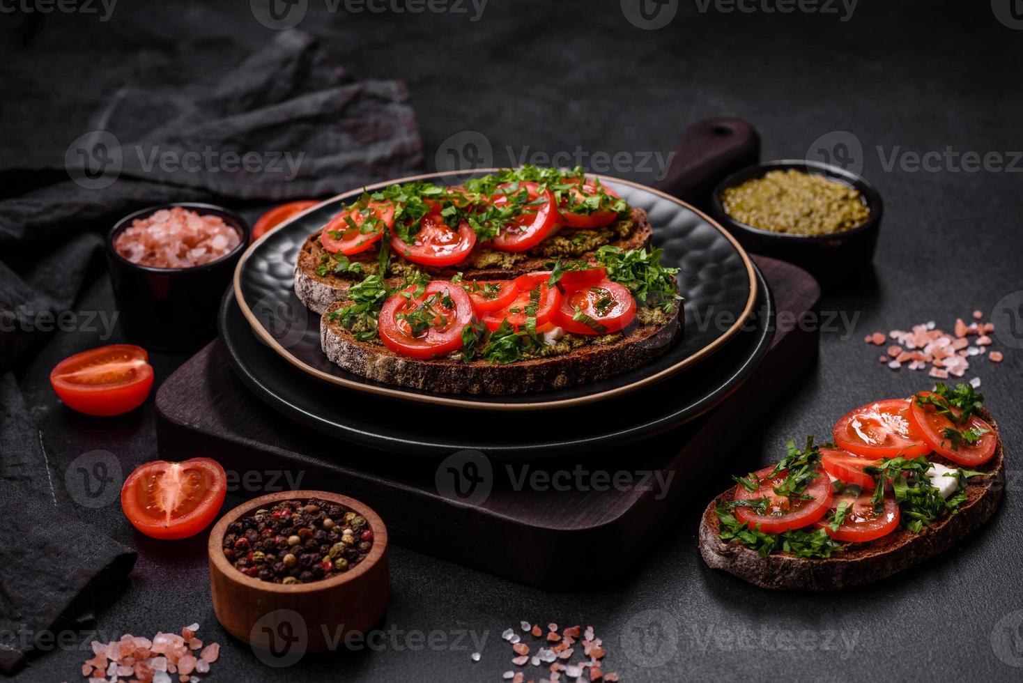 sabrosa bruschetta con tomates, mozzarella, albahaca, especias y hierbas foto