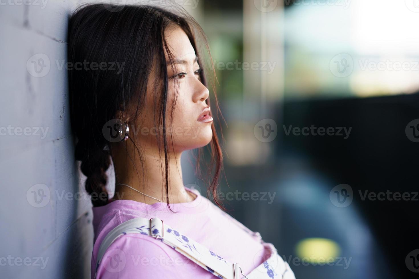 Asian woman leaning on wall photo