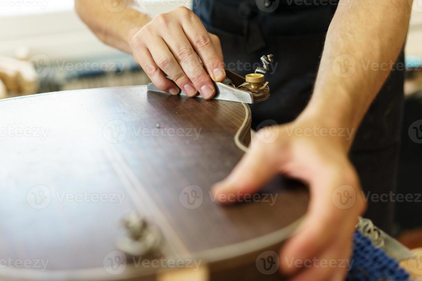 Unrecognizable male luthier crafting Spanish flamenco guitar photo