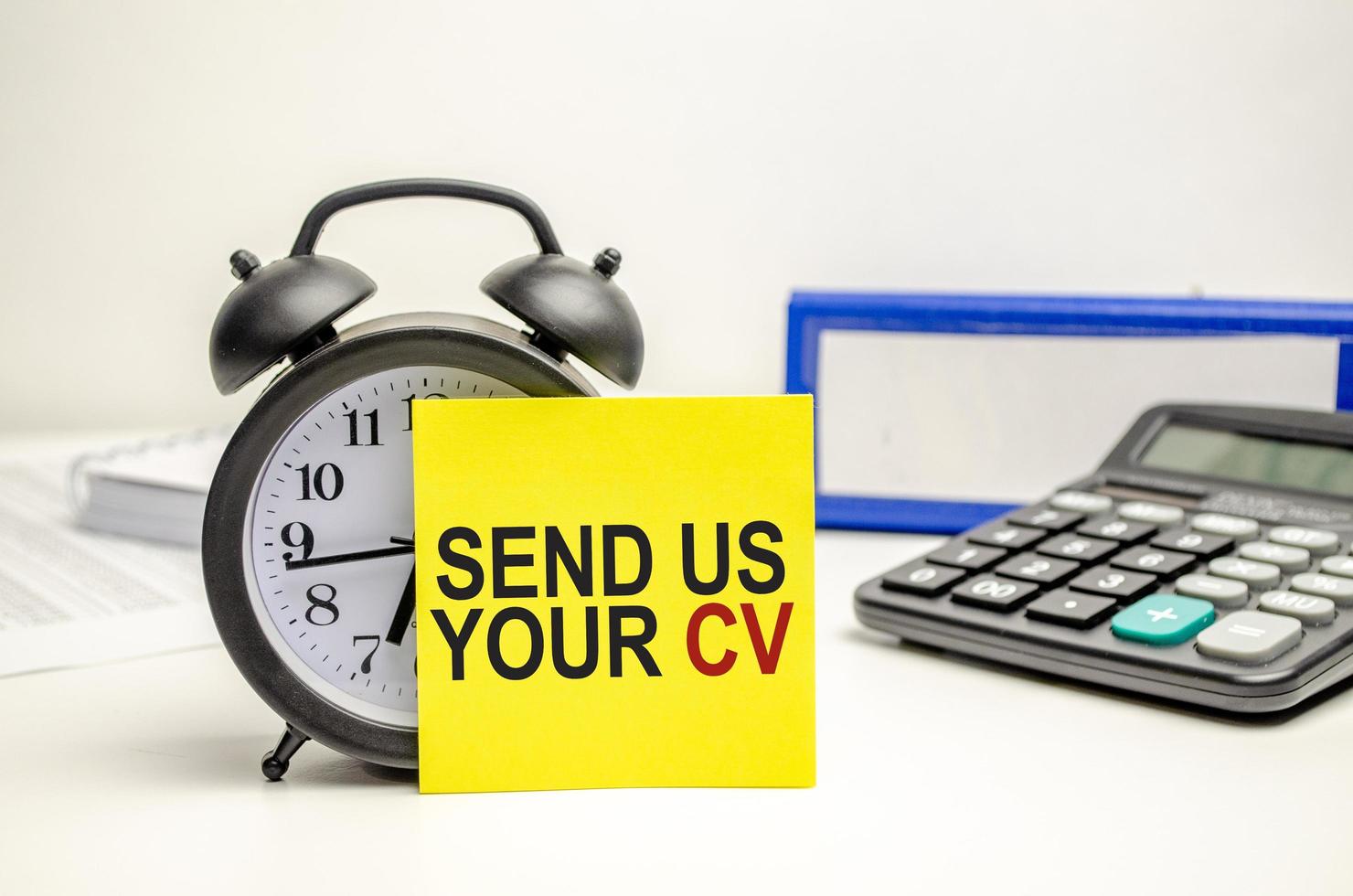 send us your cv words on yellow sticker with calculator, clock and paper folder photo