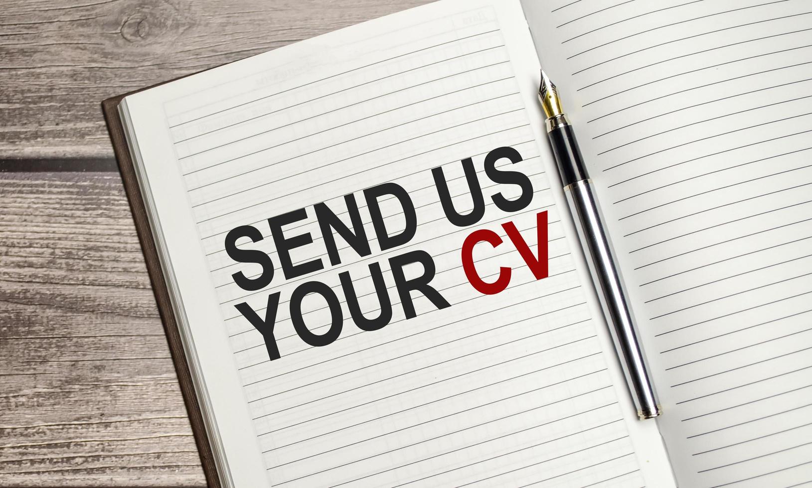 brown diary, send us your cv words and pen on wooden background photo