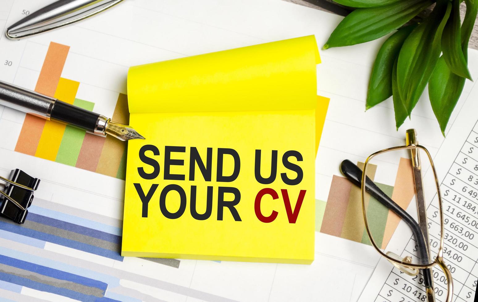 yellow sticker , charts, pen and send us your cv words photo