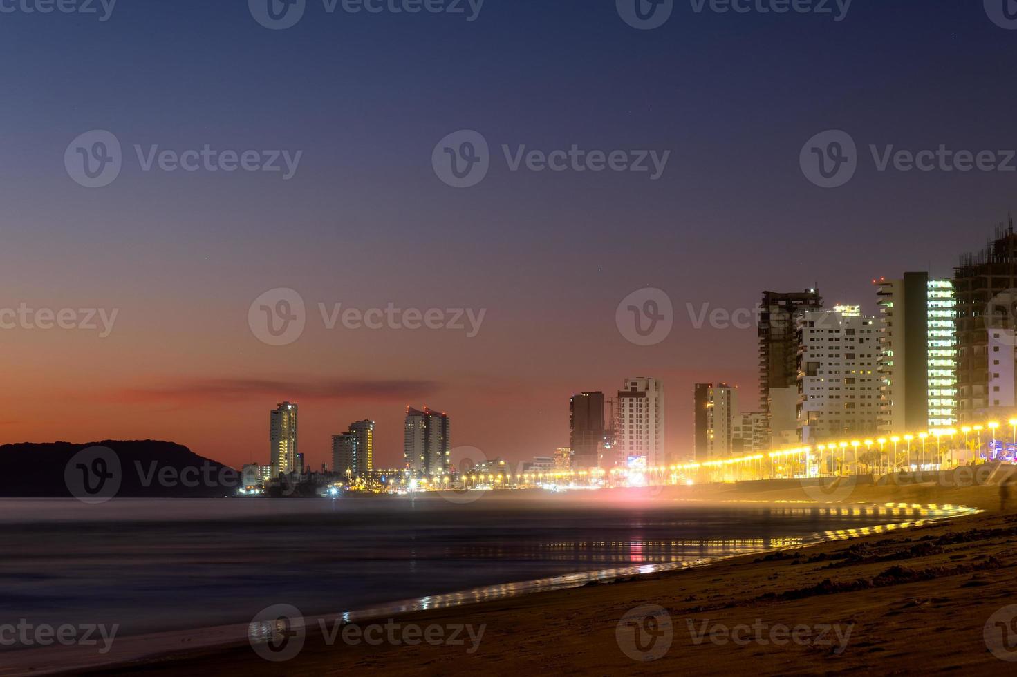 Mazatlan sinaloa beach at night with luminous city in the background photo