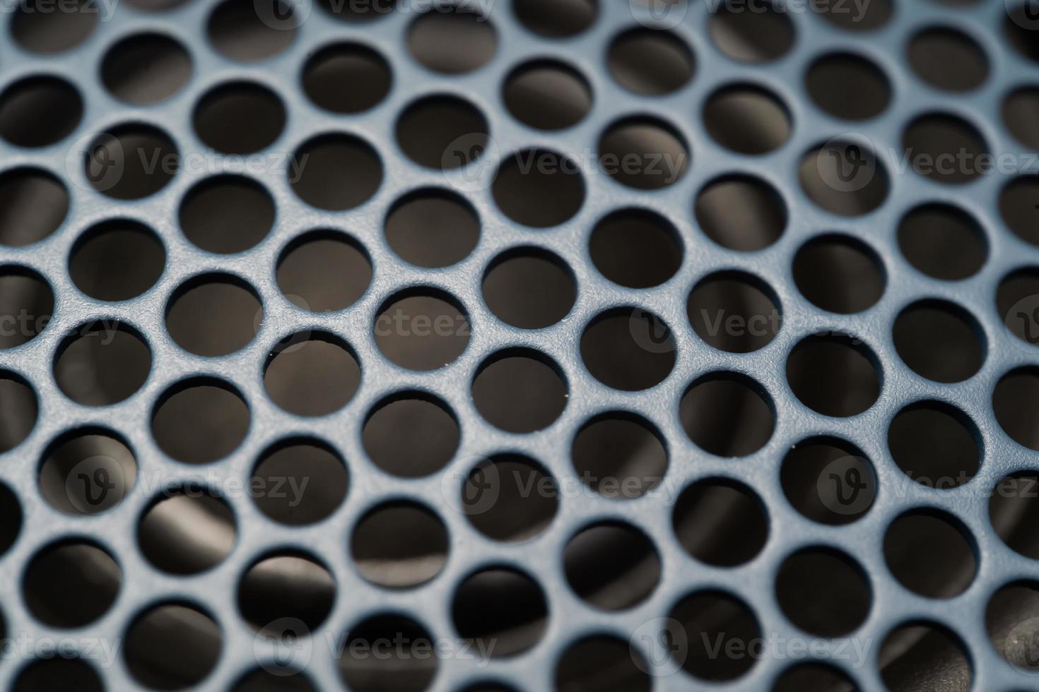 Fragment of the speaker with a metal perforated grille. Speaker texture, blue and black. Macro shot of speaker grille. Vintage effect. Close up shot of Acoustic broadband speaker. photo