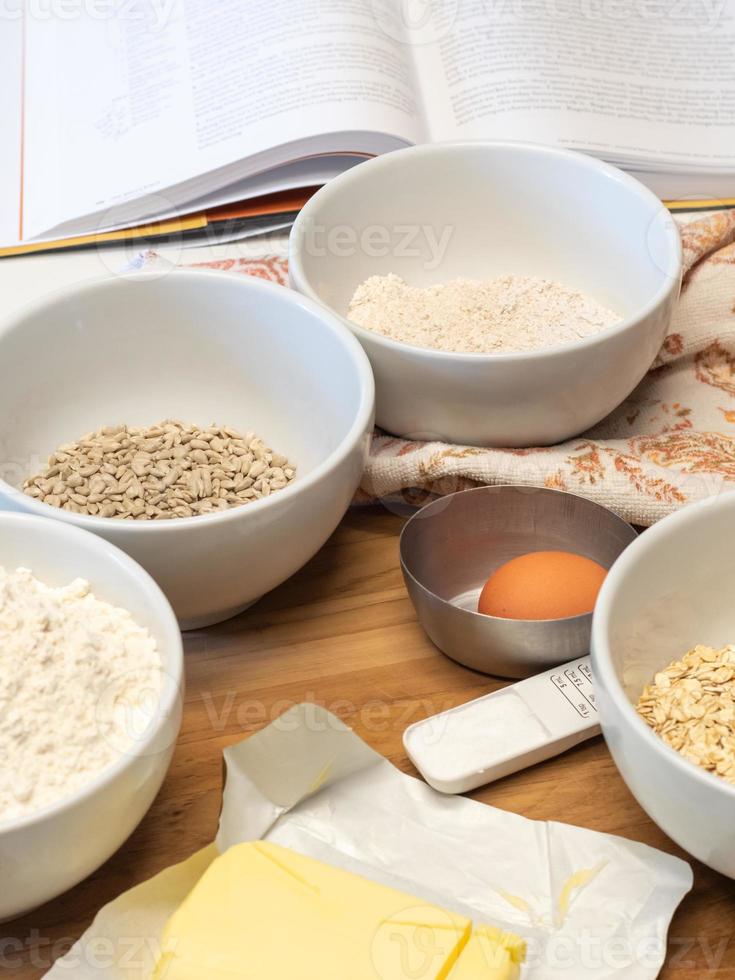 Some of the ingredients for baking bread placed next to a cook book. photo