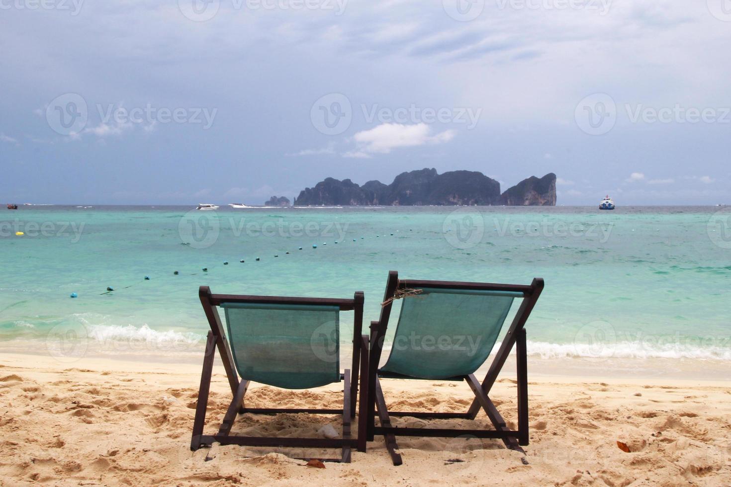 Travel to island Phi Phi, Thailand. Two chairs on a beach near to sea. photo