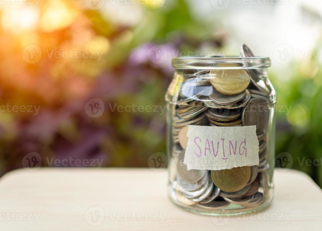 Coins in glass bottles on nature background. The concept of savings and investment. photo