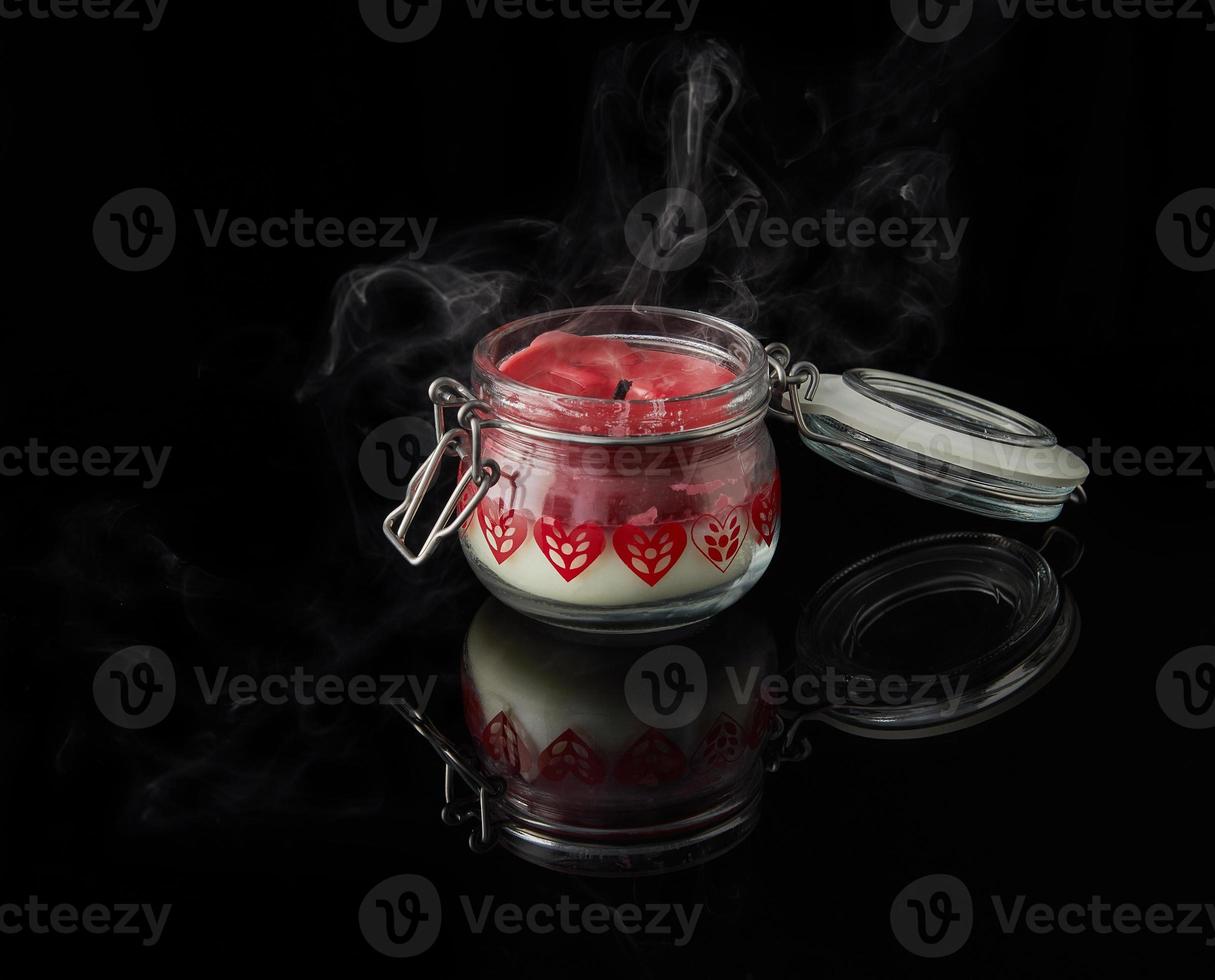 An extinguished candle with smoke on black background with aromas of