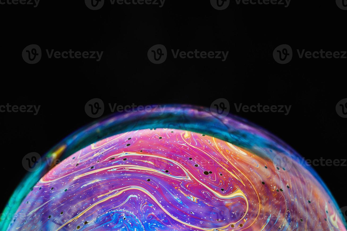 Virtual reality space with abstract multicolor psychedelic planet. Closeup Soap bubble like an alien planet on black background. photo