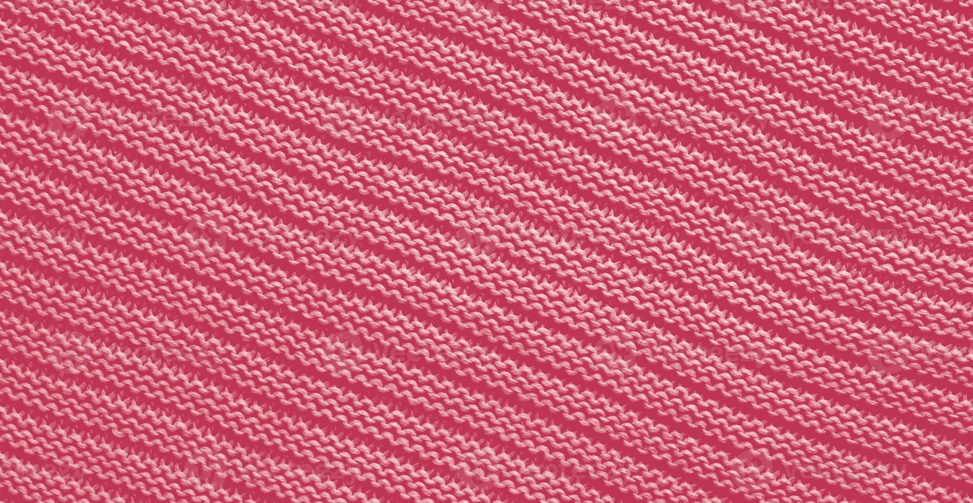 Texture of smooth knitted sweater with pattern. Handmade knitting wool or cotton fabric texture. Background of Large knit pattern with knitting needle or crochet. Color Of The Year 2023 - Viva Magenta photo