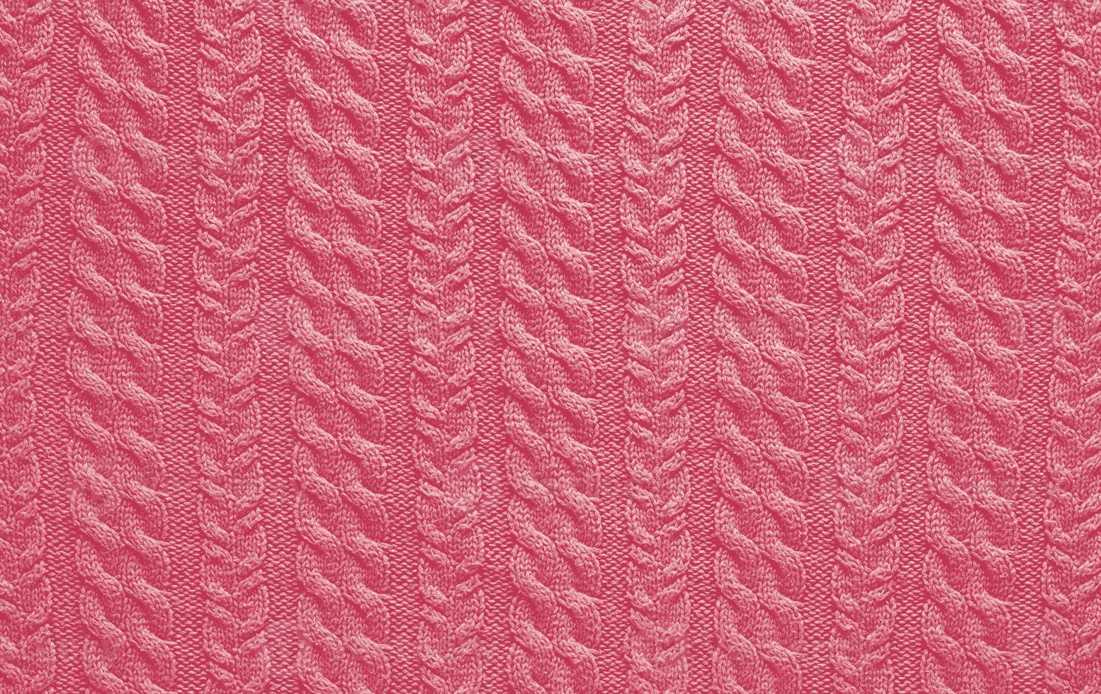 Texture of smooth knitted sweater with pattern. Handmade knitting wool or cotton fabric texture. Background of Large knit pattern with knitting needle or crochet. Color Of The Year 2023 - Viva Magenta photo
