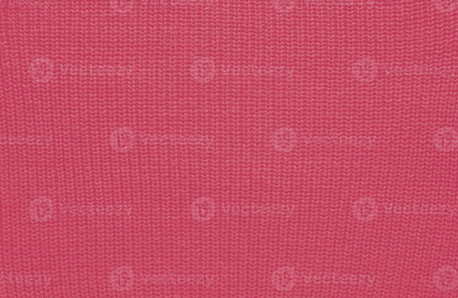 Texture of smooth knitted sweater with pattern. Handmade knitting wool or cotton fabric texture. Background of Large knit pattern with knitting needle or crochet. Color Of The Year 2023 - Viva Magenta photo