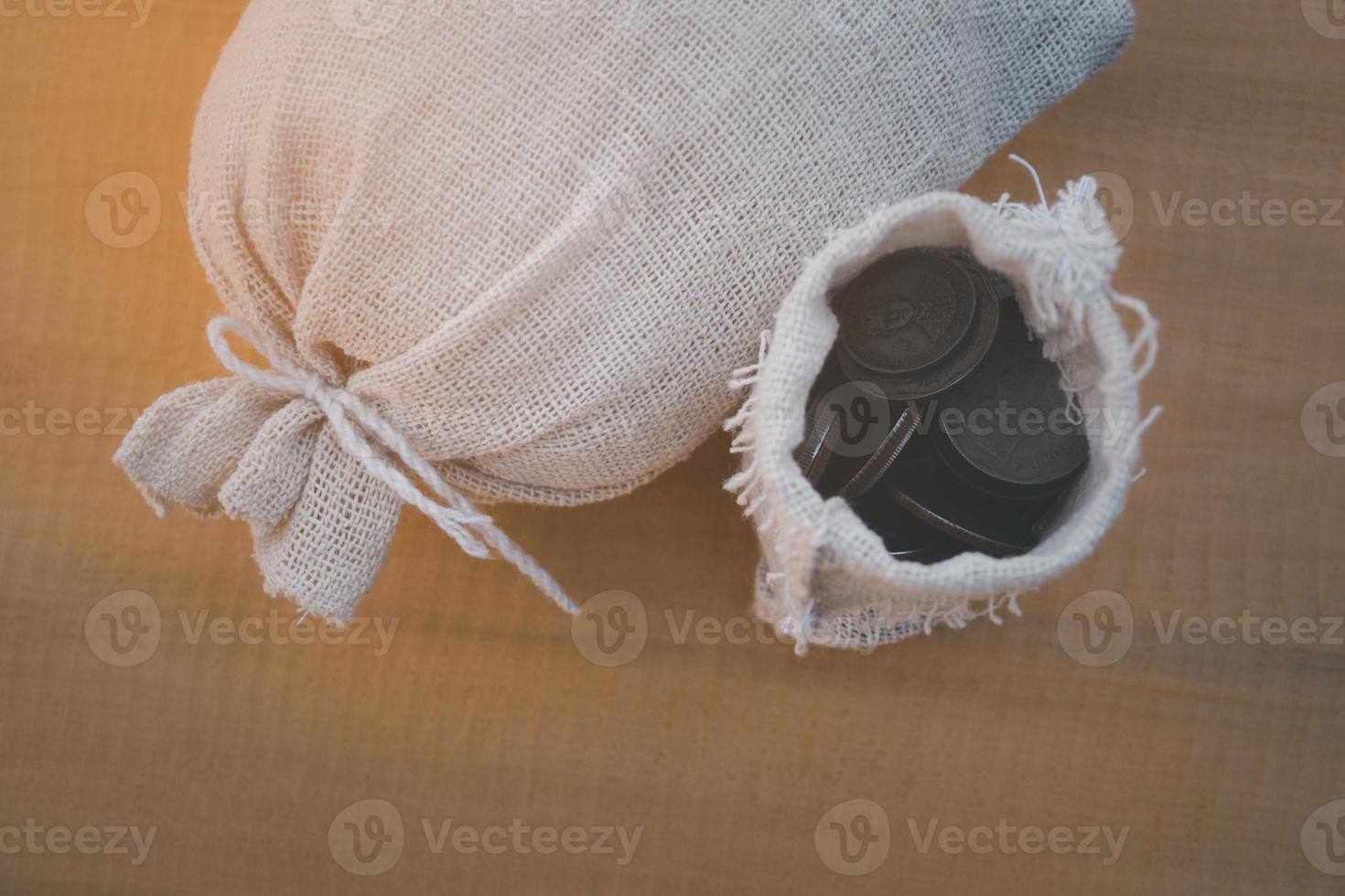 Top view of money back on the wooden background and open bag photo