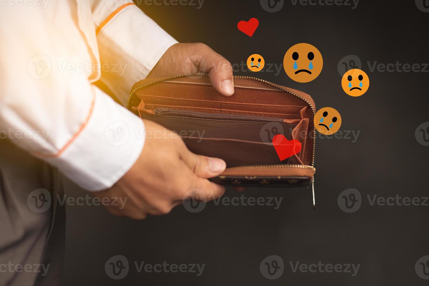 Closeup shot hand holding empty wallet and computer sad icon and light photo