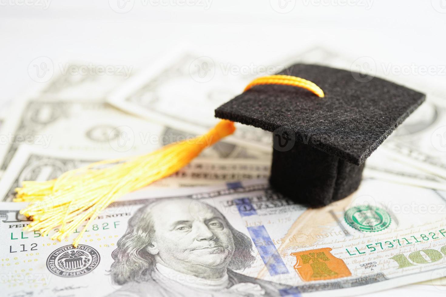 sombrero de la brecha de graduación en el dinero de los billetes en dólares estadounidenses, concepto de enseñanza de aprendizaje de la tarifa de estudio de educación. foto