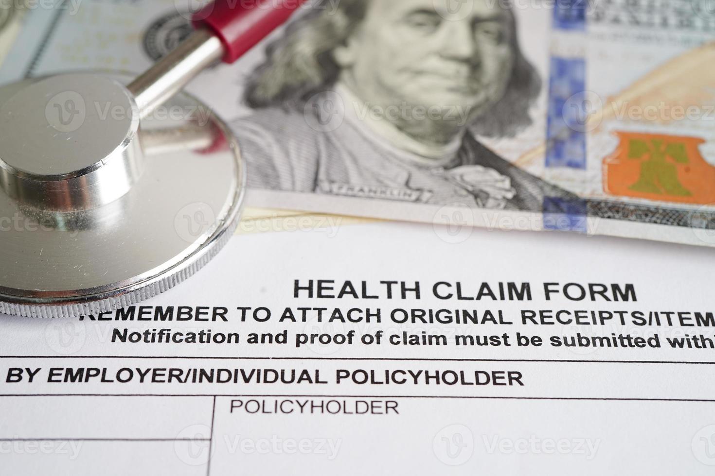 Health claim form with stethoscope and US dollar banknotes, insurance accident medical concept. photo